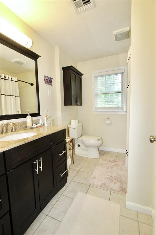 239 Union St, Franklin, MA 02038 - full bathroom featuring tile patterned floors, vanity, toilet, baseboards, and a shower with curtain