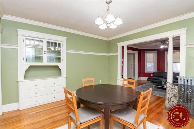 dining space with light wood-type flooring, baseboards, ornamental molding, and ceiling fan with notable chandelier