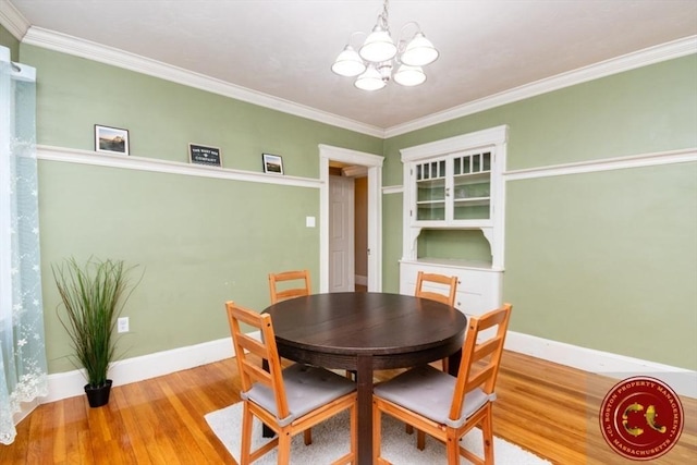 dining space with a chandelier, baseboards, and wood finished floors