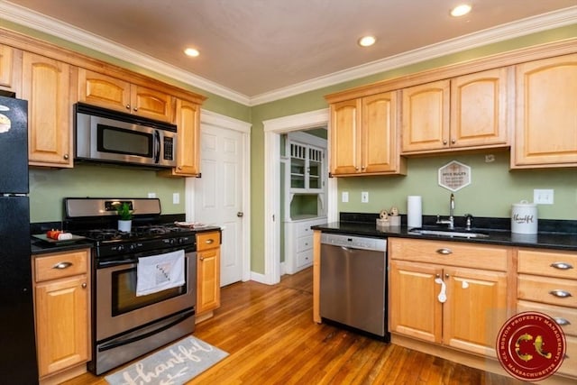 kitchen with crown molding, recessed lighting, appliances with stainless steel finishes, wood finished floors, and a sink