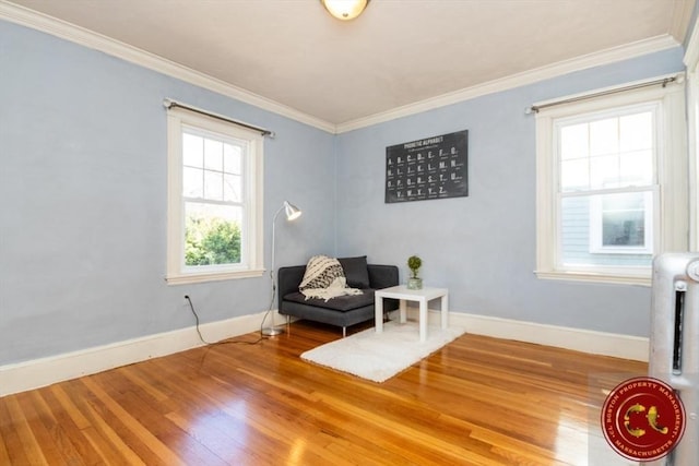 sitting room with crown molding, baseboards, and wood finished floors