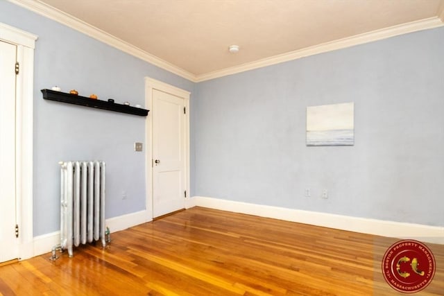 unfurnished room featuring crown molding, radiator, and wood finished floors