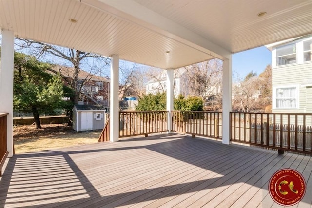 wooden deck with a storage unit and an outdoor structure