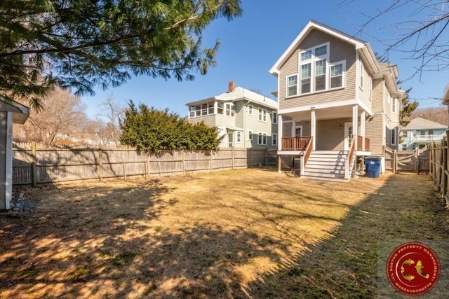 rear view of property with a lawn, covered porch, a fenced backyard, and a gate