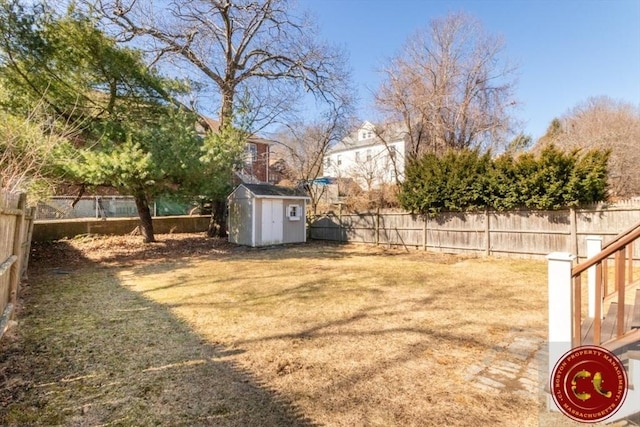 view of yard with a storage shed, a fenced backyard, and an outdoor structure