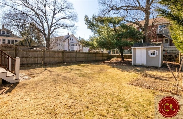 view of yard with an outbuilding, a storage unit, and fence