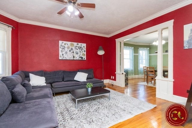 living room with a ceiling fan, crown molding, wood finished floors, and baseboards