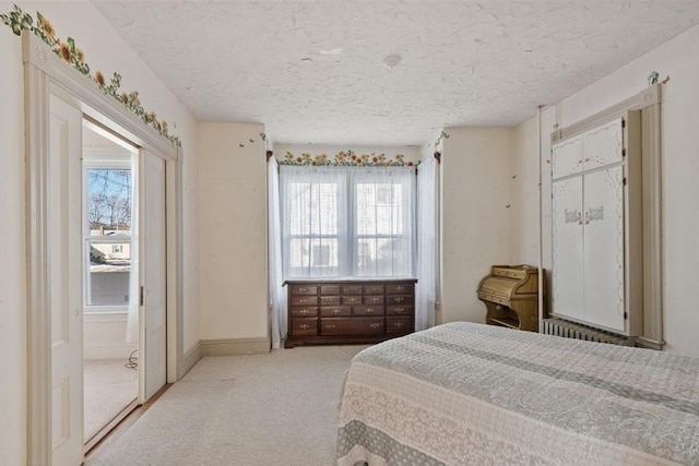 bedroom featuring light carpet and a textured ceiling