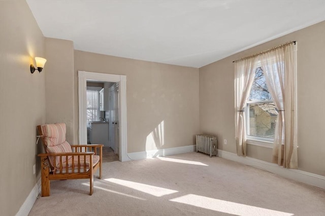 sitting room featuring light colored carpet and radiator