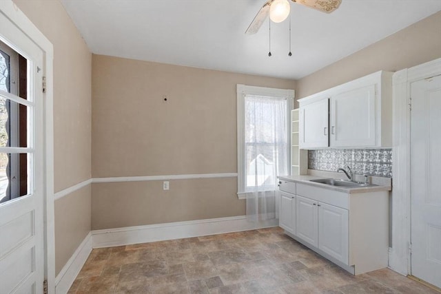 kitchen featuring tasteful backsplash, ceiling fan, sink, and white cabinets