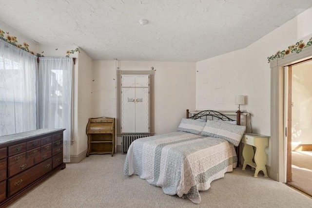 bedroom with radiator and light carpet