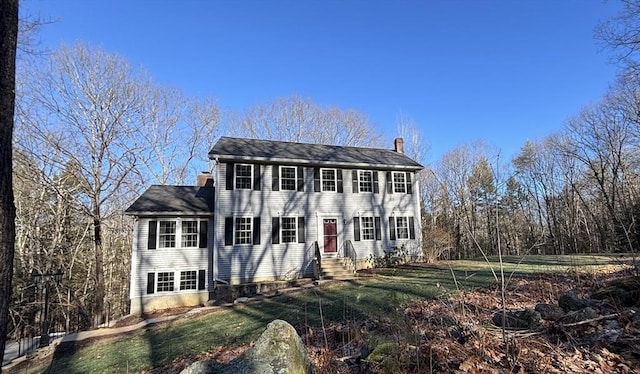 colonial home featuring a front lawn