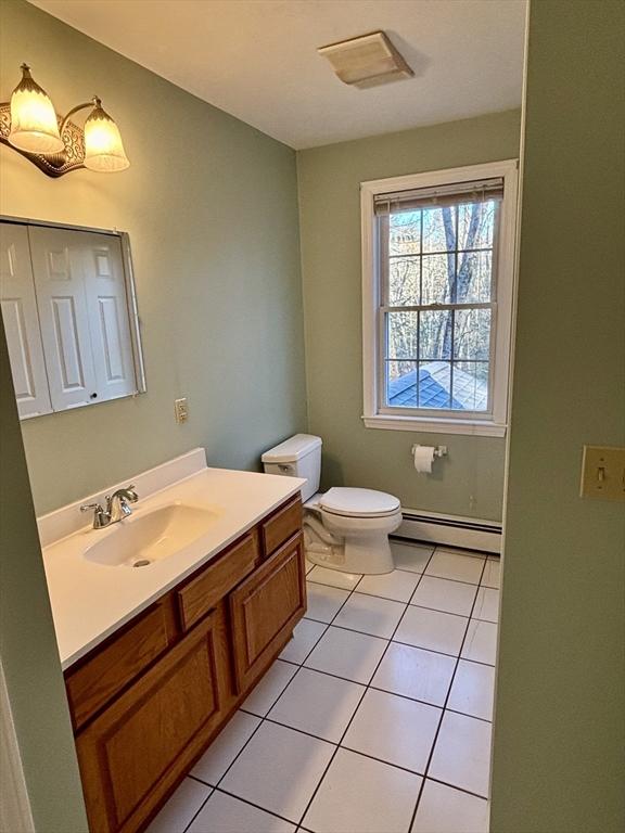 bathroom featuring tile patterned floors, toilet, vanity, and a baseboard heating unit