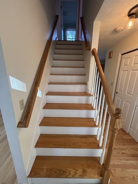 staircase with hardwood / wood-style floors