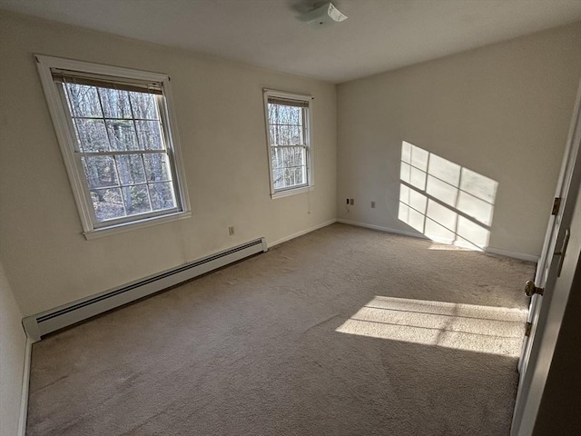 carpeted spare room with a baseboard heating unit