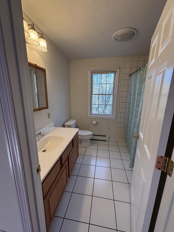 bathroom with tile patterned flooring, vanity, a baseboard radiator, and toilet