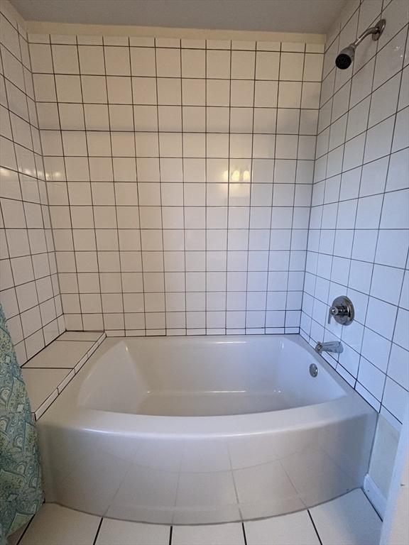 bathroom featuring tile patterned flooring and tiled shower / bath combo