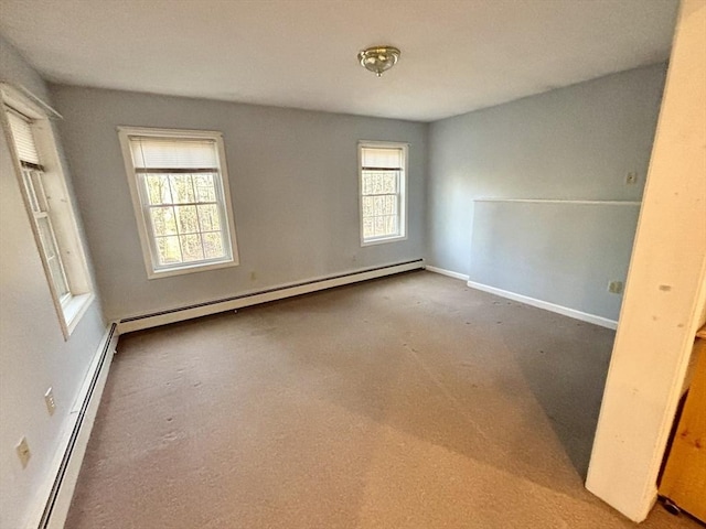 empty room with plenty of natural light, carpet floors, and a baseboard heating unit