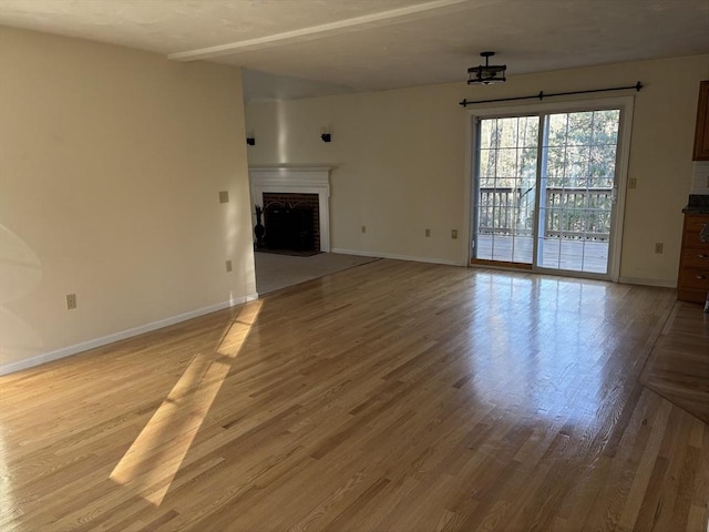 unfurnished living room with a fireplace and light hardwood / wood-style flooring