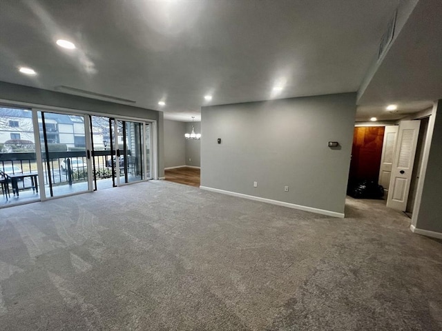 empty room with carpet and a chandelier