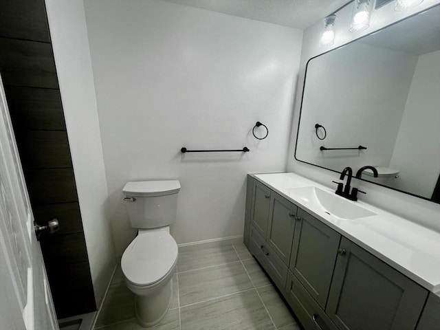 bathroom featuring tile patterned floors, vanity, and toilet