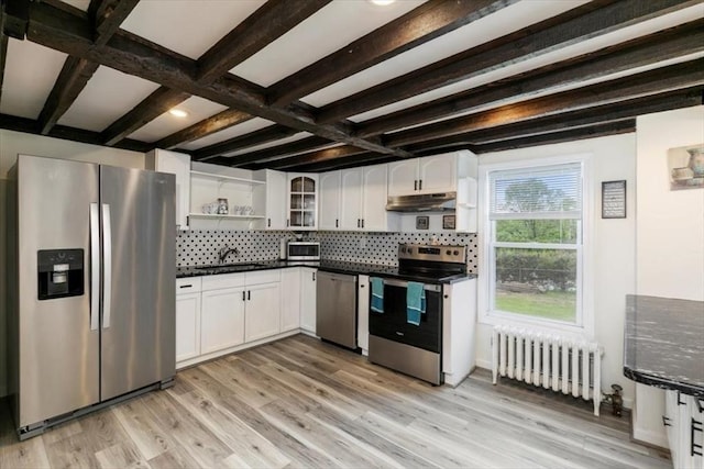 701 Nashua Rd, Dracut, MA 01826 - kitchen with stainless steel appliances, radiator heating unit, under cabinet range hood, dark countertops, and open shelves