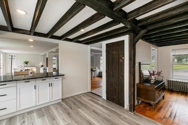 701 Nashua Rd, Dracut, MA 01826 - kitchen with radiator, light wood-style floors, white cabinets, dark stone countertops, and beam ceiling
