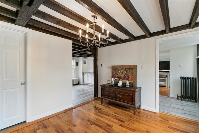 701 Nashua Rd, Dracut, MA 01826 - dining area with radiator heating unit, beam ceiling, a chandelier, light wood finished floors, and baseboards