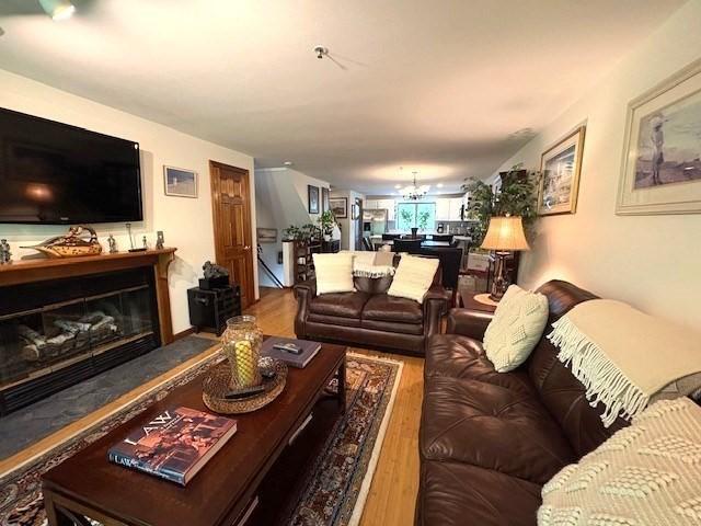 66 Schooner Lndg Unit 66, Hampton, NH 03842 - living room with wood finished floors, a chandelier, and a glass covered fireplace