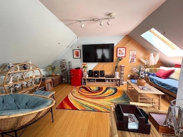 66 Schooner Lndg Unit 66, Hampton, NH 03842 - playroom featuring a skylight, vaulted ceiling, wood finished floors, rail lighting, and wood walls