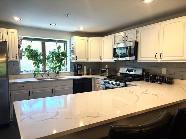 66 Schooner Lndg Unit 66, Hampton, NH 03842 - kitchen with appliances with stainless steel finishes, a sink, tasteful backsplash, light stone countertops, and recessed lighting
