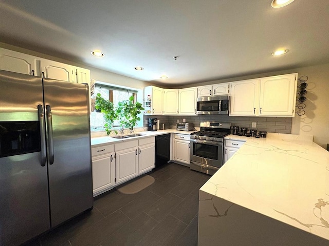 66 Schooner Lndg Unit 66, Hampton, NH 03842 - kitchen featuring appliances with stainless steel finishes, a sink, light stone counters, backsplash, and white cabinetry