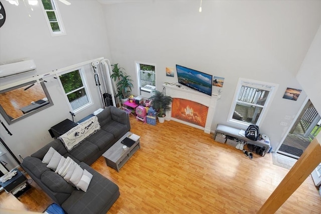 452 Nathan Ellis Hwy, Mashpee, MA 02649 - living room featuring a towering ceiling, wood finished floors, and a warm lit fireplace