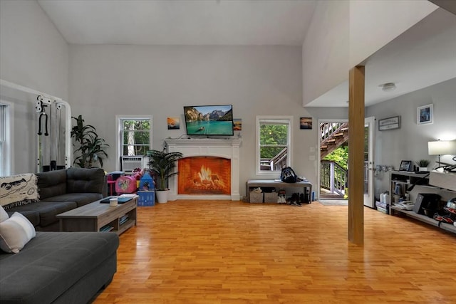 452 Nathan Ellis Hwy, Mashpee, MA 02649 - living area featuring light wood finished floors, a warm lit fireplace, and a towering ceiling