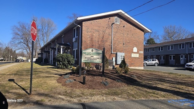 view of side of home with a yard and brick siding