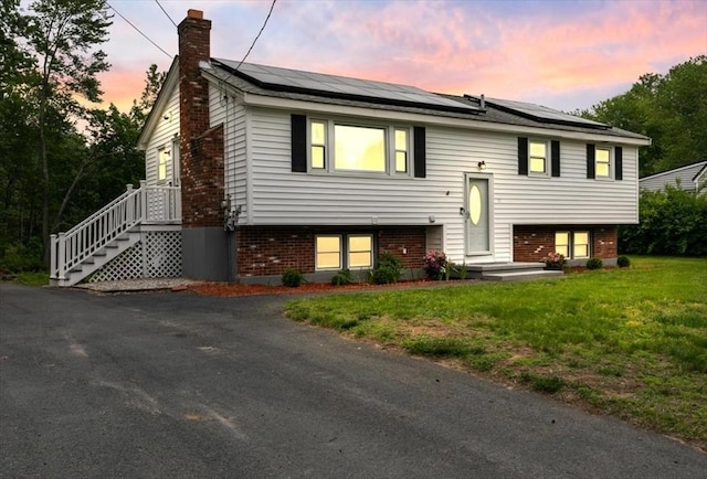 30 Shawnee, Pepperell, MA 01463 - split foyer home featuring a chimney, brick siding, solar panels, and a yard
