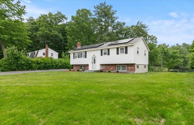 30 Shawnee, Pepperell, MA 01463 - split foyer home with roof mounted solar panels, a front lawn, and a chimney