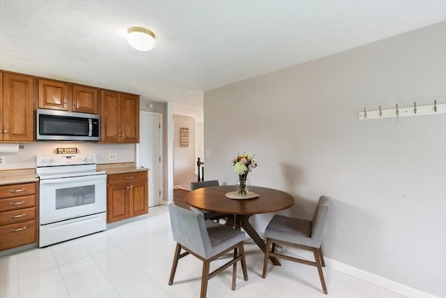30 Shawnee, Pepperell, MA 01463 - kitchen with stainless steel microwave, white electric range oven, brown cabinets, and light countertops
