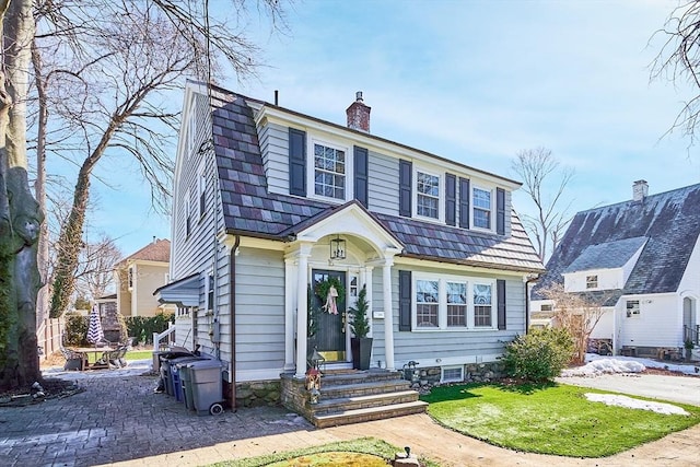 dutch colonial featuring entry steps, a chimney, and a gambrel roof