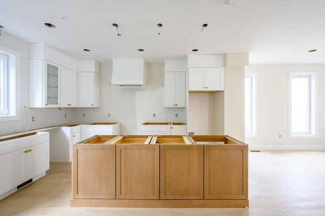 kitchen with white cabinets, a center island, and a wealth of natural light