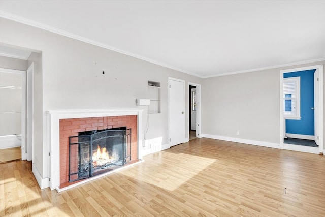 unfurnished living room with a fireplace, crown molding, and light hardwood / wood-style flooring