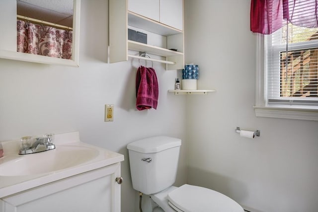 full bath with healthy amount of natural light, toilet, and vanity