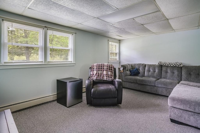 carpeted living room with baseboard heating and a drop ceiling