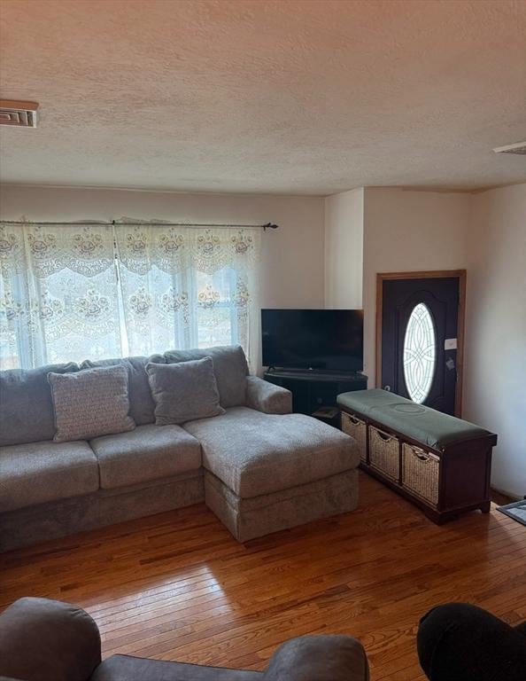 living room with wood-type flooring and a textured ceiling