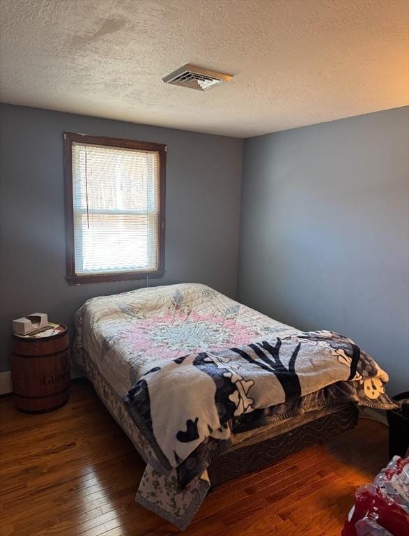 bedroom featuring dark wood-type flooring and a textured ceiling