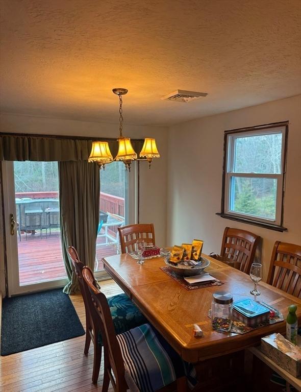 dining area featuring a chandelier, a textured ceiling, and hardwood / wood-style floors