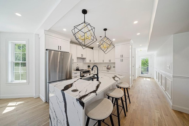 1135-1137 Hyde Park Ave Unit 1, Boston, MA 02136 - kitchen featuring healthy amount of natural light, appliances with stainless steel finishes, a breakfast bar area, white cabinetry, and recessed lighting