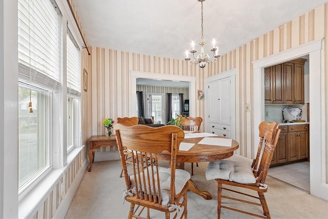 dining area with wallpapered walls, a chandelier, and light colored carpet