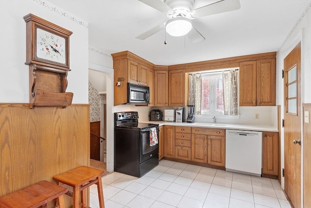 kitchen featuring black appliances, light countertops, and brown cabinetry