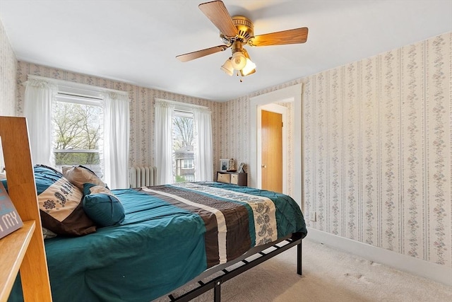 carpeted bedroom featuring wallpapered walls and a ceiling fan